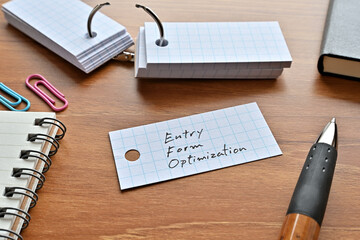 Poster - There is a word book with the word Entry Form Optimization written on it with a pen and notebook.