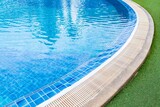 Fototapeta  - Wide swimming pool and green artificial turf inside the villa