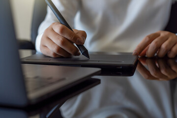 Wall Mural - graphic designer using digital tablet with electronic pen and work on laptop computer at the desk in office. 