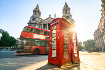 Sticker - Red Telephone booth at sunrise with blurry bus passing by near St Pauls Cathedral in London