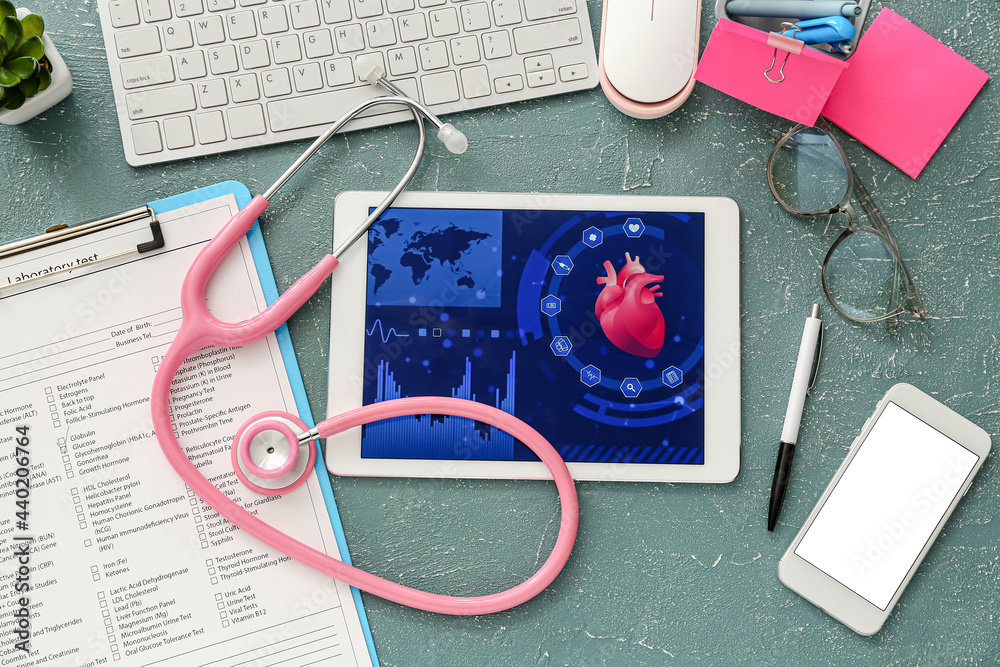 Tablet computer with stethoscope and laboratory test form on color background