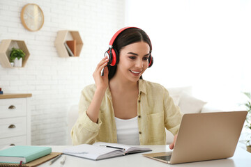 Poster - Young woman watching online webinar at table indoors