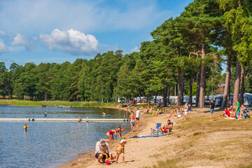 Wall Mural - Bathing lake with a sandy beach and sunbathing people