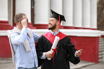 Wall Mural - Happy young man with his father on graduation day