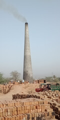 Canvas Print - Vertical shot of a brick factory with smoke in India