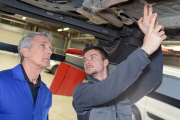 student with instructor repairing a car during apprenticeship