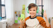 © Syda Productions - leisure, technology and people concept - happy smiling boy with smartphone and headphones listening to music and showing thumbs up at home over children's room background