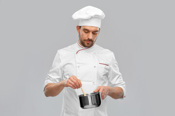 Wall Mural - cooking, culinary and people concept - male chef in toque with pot or saucepan over grey background