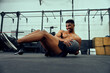 © StratfordProductions - African American male doing an intense workout in the gym. Male athlete doing sit-ups with medicine ball. High quality photo