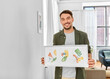© Syda Productions - home improvement, decoration and art concept - happy smiling man holding watercolor picture in frame