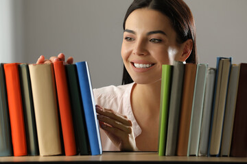 Poster - Woman searching for book on shelf in library