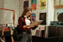 Young Woman With Vinyl Record In Store