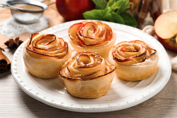 Freshly baked apple roses on white wooden table. Beautiful dessert