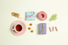 Gift Boxes, Cup Of Black Tea, Pink String, Wooden Clip, Dry Flowers On Yellow Green Background. Flat Lay, Top View, Copy Space