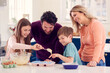 © Monkey Business - Family With Two Children In Kitchen At Home Having Fun Baking Cakes Together