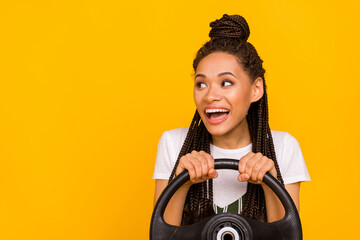 Wall Mural - Photo of amazed happy afro american young woman look empty space drive car smile isolated on yellow color background