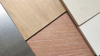 close up interior material board including wooden laminated, oak vinyl flooring tile, beige artificial stone, brushed metallic plate samples. combination of interior material samples for renovation. 