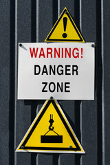 A danger zone warning with triangle signs Warning about falling cargo hazard. Danger zone caution signs at the construction site, vertcial image.