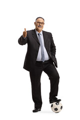 Poster - Full length portrait of a mature man in suit and tie stepping on a soccer ball and gesturing thumbs up