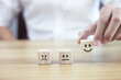 © kelvn - Satisfaction concept, businessman choose smiley face icon on wooden cube, service rating.
