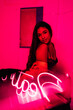 © ADDICTIVE STOCK - Hispanic woman resting near neon inscription