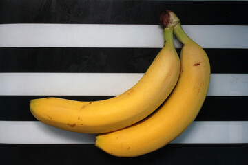 Two ripe bananas on a black and white background.