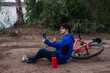 © Hugo - Young cyclist taking a selfie, resting on the ground next to his bike