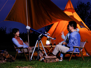 A happy family of three using telescopes outdoors