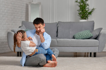 father playing with excited happy little child girl