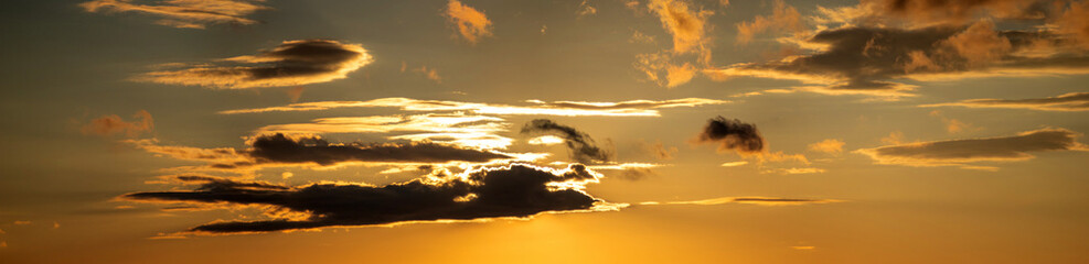 Wall Mural - the sun shines through the clouds at sunset