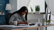 © DC Studio - Black student writing education ideas on stickey notes sitting at desk table in living room. Young woman studying business at univeristy using elearning platoform working remote from home