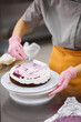 © Anischenko - A bright pastry chef girl is engaged in the preparation of a cake