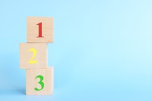 Colorful 123 Numbers On Wooden Blocks In Blue Background With Copy Space. Start Of Child Or Kid Learning Counting Concept.	