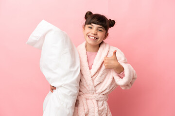 Wall Mural - Little caucasian girl isolated on pink background in pajamas and with thumbs up because something good has happened