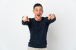 © luismolinero - Young caucasian man isolated on white background surprised and pointing front