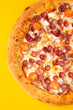 © Игорь Соколов - Pizza with sausages and tomatoes. On a yellow background.