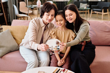 Poster - Females of three generations looking in mirror while sitting on couch