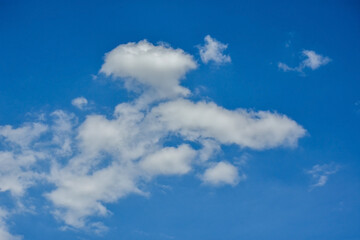 Beautiful cumulus clouds against the blue daytime sky.