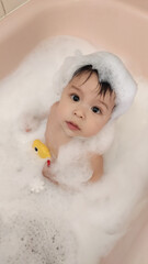 Canvas Print - High angle shot of a cute toddler taking a bath