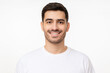 © Damir Khabirov - Portrait of young handsome smiling man wearing white t-shirt, isolated on gray background