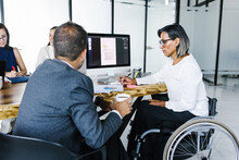 Mexican Transgender Woman In A Wheelchair With A Businessman Using A Smartphone And Teamwork In Disability Concept And Disabled People