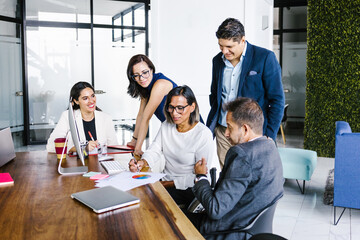 Wall Mural - Latin transgender businesswoman in wheelchair working with colleagues in office in Latin America, in disability concept and disabled people