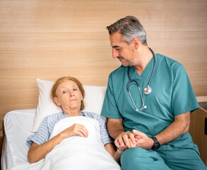 Doctor holding elderly woman patients hands in day hospital. Doctor helping elderly patients with Alzheimer's disease..