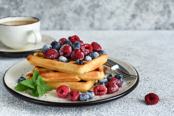 Wall Mural - Vanilla Belgian waffles with berries and a cup of coffee for breakfast.