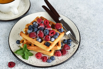 Wall Mural - Vanilla Belgian waffles with berries and a cup of coffee for breakfast.