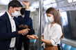 © NVB Stocker - Crowd of passengers on Urban Public Transport Metro. Asian people go to work by public transport. Face Mask protection against virus. Covid-19, coronavirus pandemic