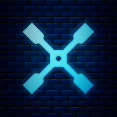 Sticker - Glowing neon Wheel wrench icon isolated on brick wall background. Wheel brace. Vector