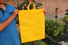 Male Demonstrating A Yellow Woven Eco-handbag
