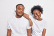 © WHstudio Leushin N - Afro American female and male friends spend free time together look with flirting expressions at each other dressed casually isolated over white background. Friendship and relationship concept