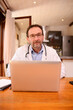 © W PRODUCTION - handsome male doctor giving a remote medical consultation over internet computer telemedecine diagnostic from home